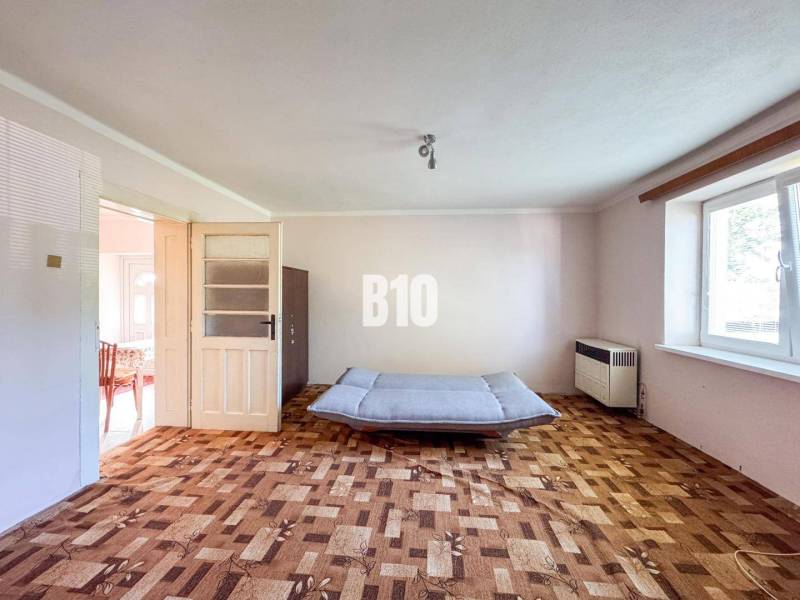 Nappali egy családi házban fa mintás padlóval és kanapéval.