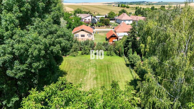 Kert zölddel és családi házakkal körülvéve Újszádon.