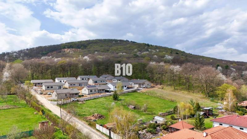 Lakóterületek Jelenecen, zölddel és erdőkkel körülvéve a lejtőkön.
