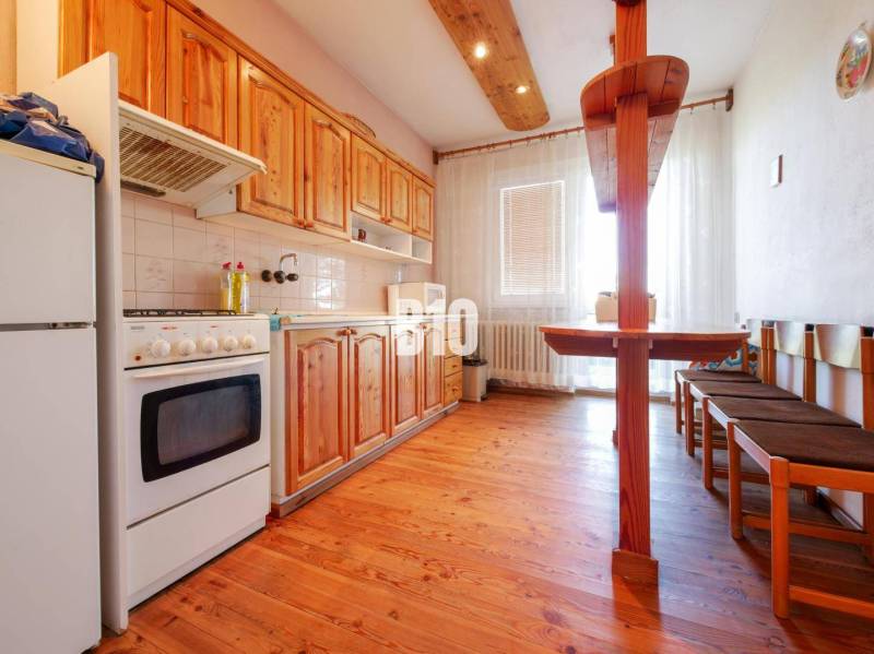 Konyha családi házban fa dekorációval és étkezősarokkal.