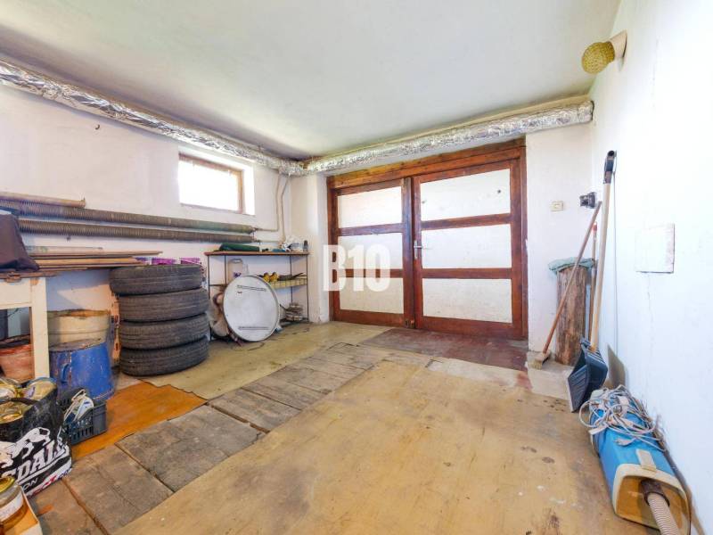 Garázs egy családi házban faajtókkal és fa dekorációhoz hasonló padlóval.