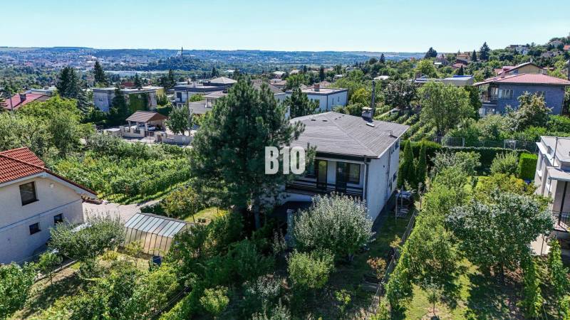 Kilátás a Kamenná utcai családi házra Nyitrán, zölddel és városi panorámával körülvéve.