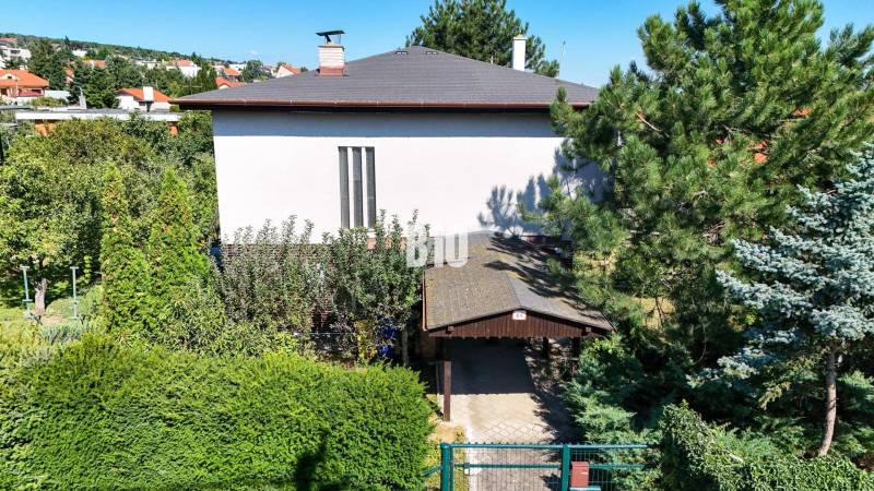 Családi ház a Nyitrai Kő utcában, zölddel és fákkal körülvéve.