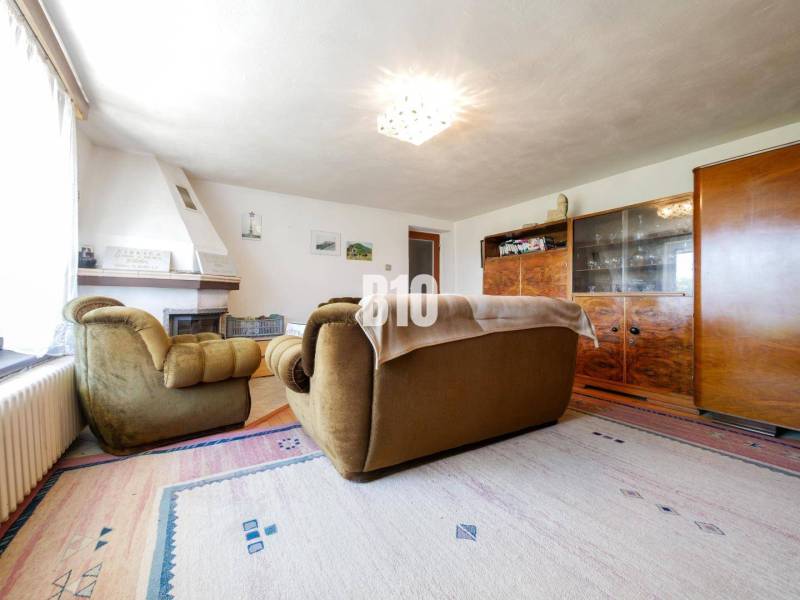 Nappali kandallóval és retro bútorokkal egy családi házban, fa dekoros padlóval.