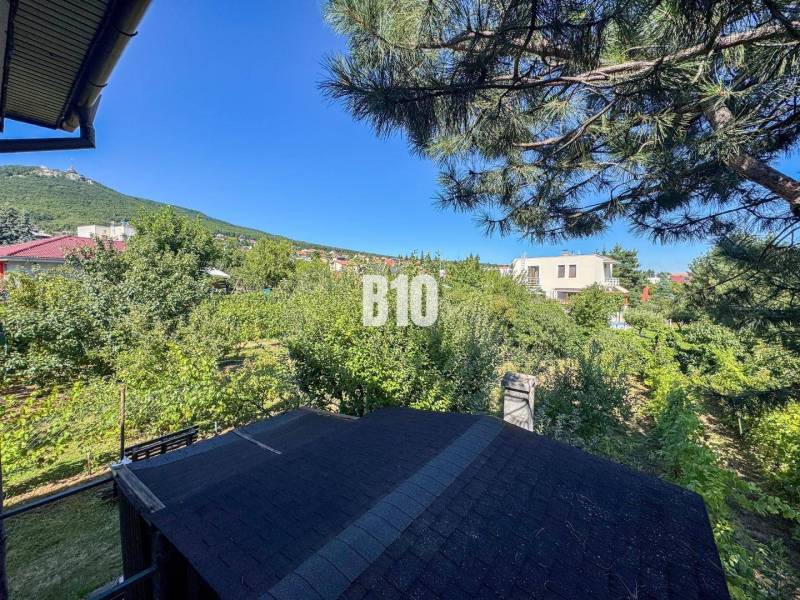 Kert egy családi ház mellett a Kamenna utcában, Nyitrán, kilátással az erdőre.