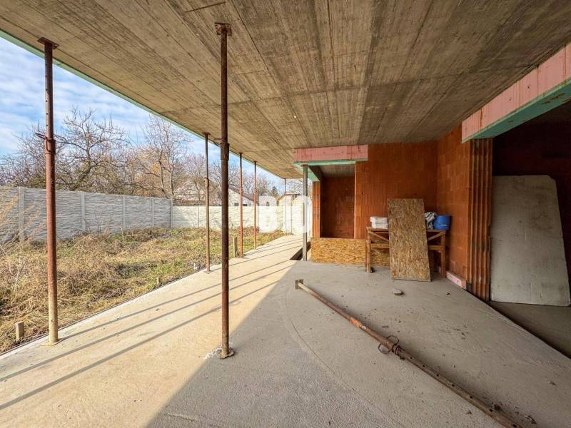 Családi ház építése kezdeti fázisban, fa panelekkel és beton mennyezettel.