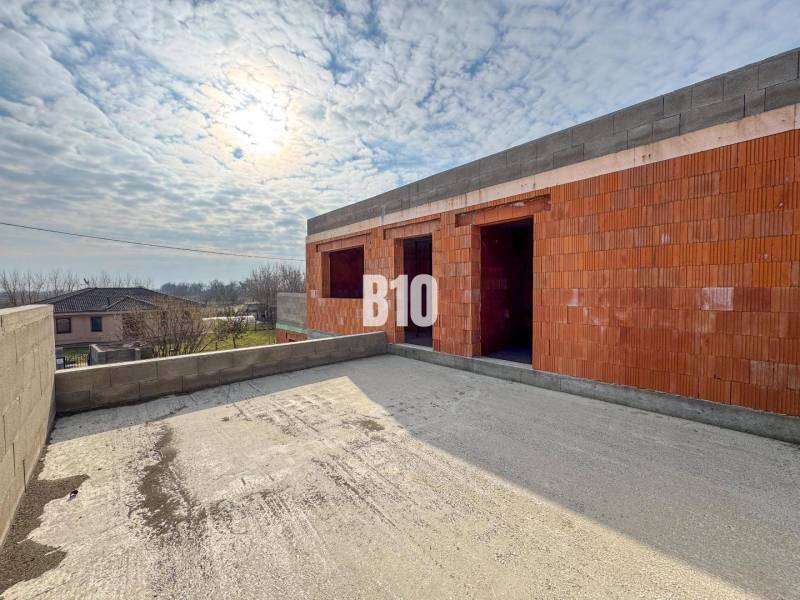 Családi ház építése téglából, ingatlan mellett, tiszta égbolt, építkezés.