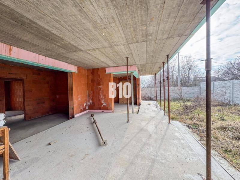 Családi ház építése tégla falakkal tágas telken a természetben.