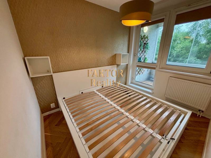 Hálószoba ággyal és nagy ablakkal, 2 szobás lakás fa dekor padlóval.