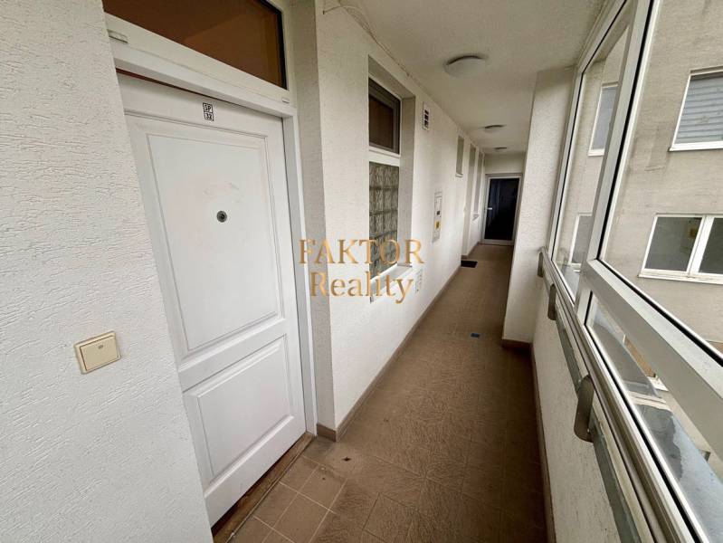 Folyosó egy kétszobás lakásban fehér ajtókkal és csempével.