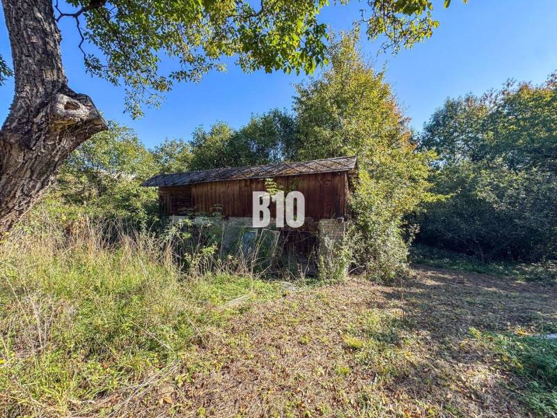 Egy ház Lackovban, amelyet fű és fák vesznek körül egy napos napon.