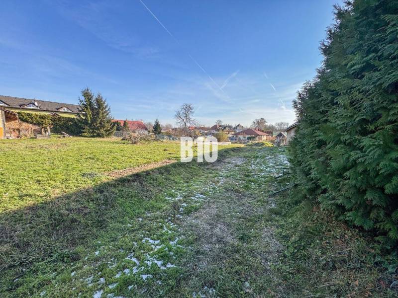 A képen egy zöld telek látható házakkal, amely lakhatásra alkalmas.