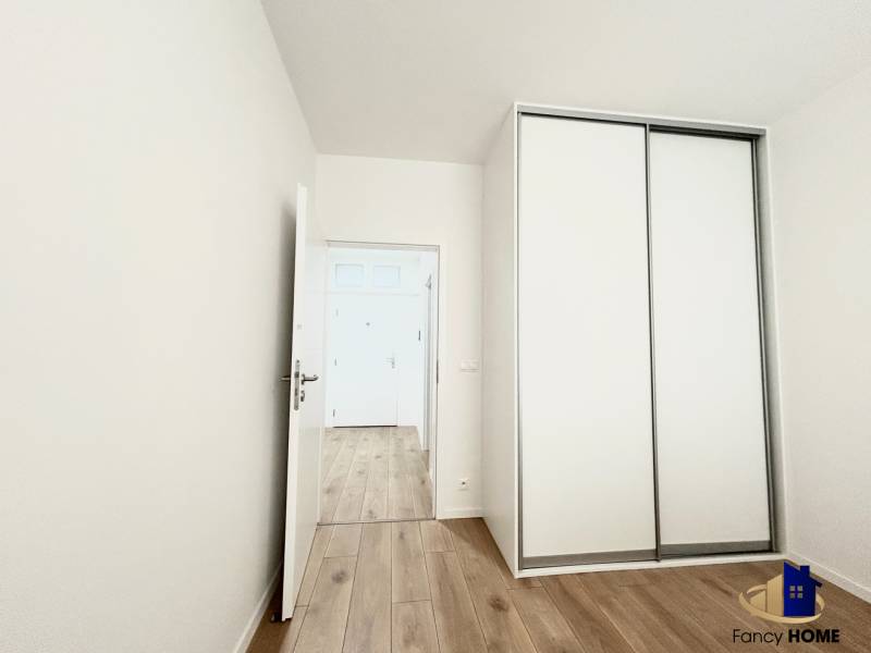 Szoba szekrénnyel és fa dekorációjú padlóval egy kétszobás lakásban.