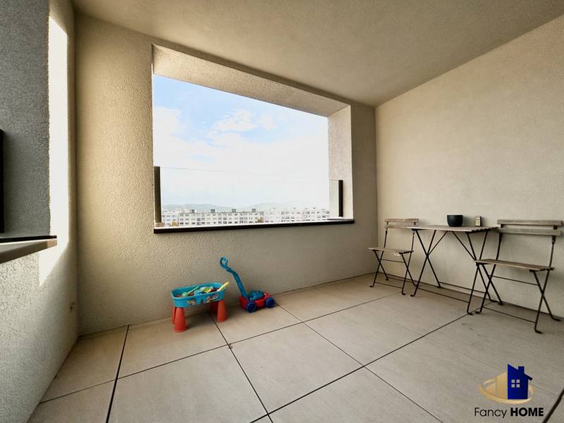 Erkély kilátással a városra, játékokkal és bútorokkal a 2 szobás lakásban.