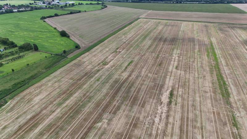 Szántóföld mezőgazdasági és erdőterületeken, Nová Ves nad Váhom, körülötte zöld rétekkel.