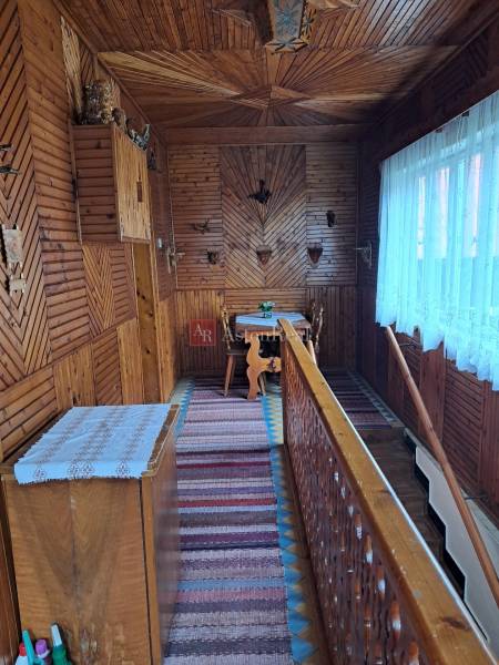 Családi ház belső tere fa dekorációjú padlóval és hagyományos fali dekorációkkal.