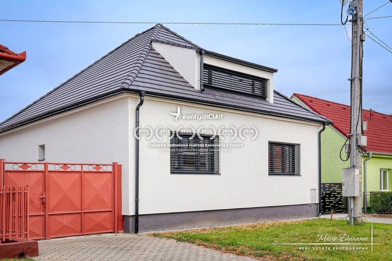 Családi ház Jaslovské Bohunice-ban, az Orechová utcában, fehér homlokzattal és fekete tetővel.