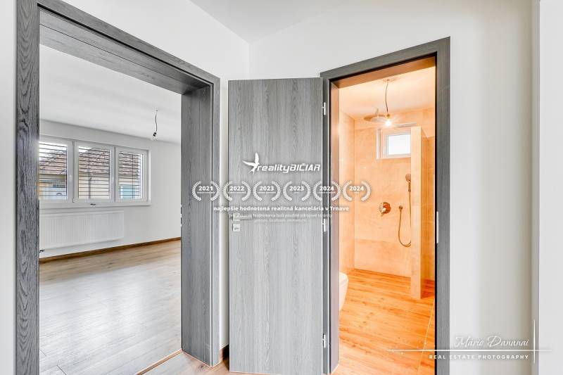 Családi ház belső tere ajtókkal, fürdőszobával és fa dekorációjú padlóval.