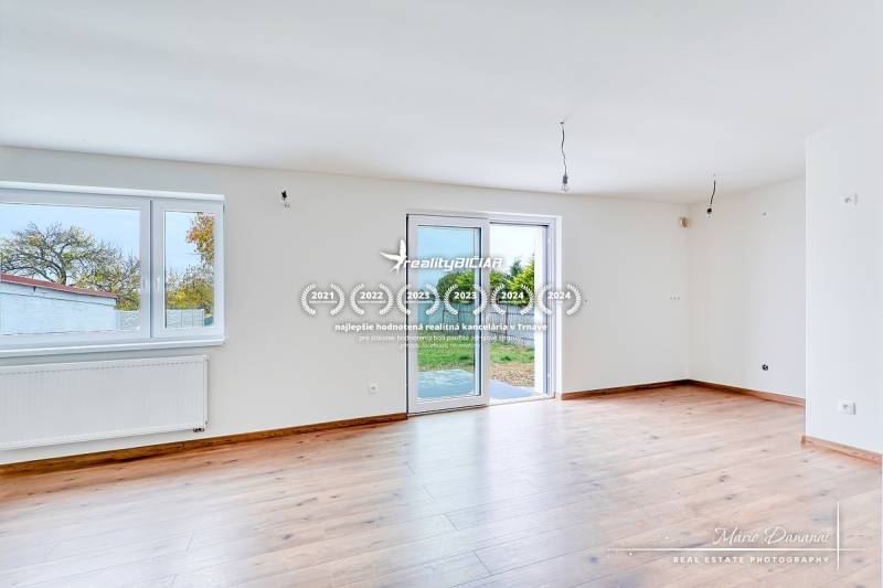 Világos szoba fa dekorációs padlóval családi házban, nagy ablakokkal, teraszra való kijárattal.