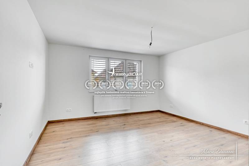 Szoba fehér falakkal és fa dekorációjú padlóval egy családi házban.