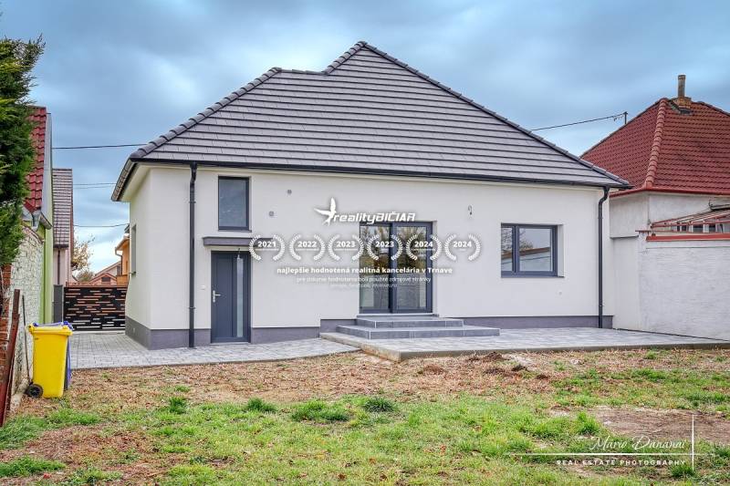 Családi ház az Orechová utcában, Jaslovské Bohunicében, füves udvarral és szilárd burkolatú járdákkal.