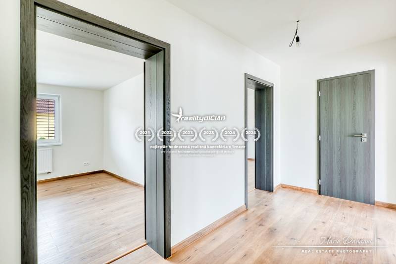 Családi ház fa dekor padlóval, ajtókkal és fehér falakkal.