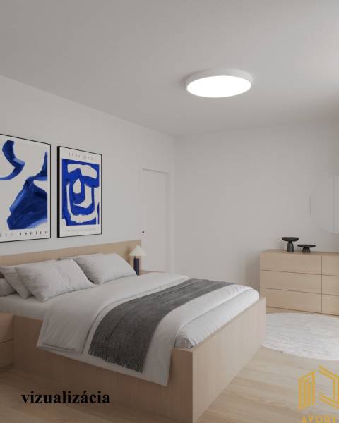 Világos hálószoba egy kétszobás lakásban, fa dekorációjú padlóval és képekkel a falon.