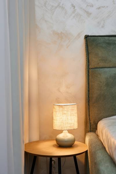 Éjjeliszekrény lámpával az ágy mellett egy kétszobás lakásban.