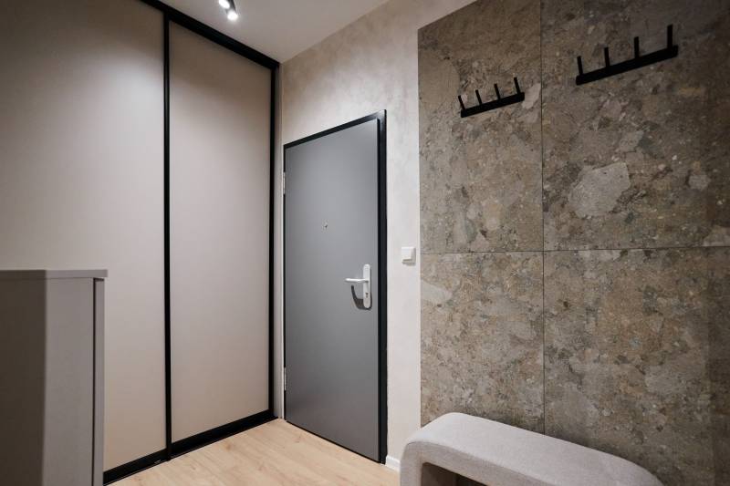 2 szobás lakás előszobája fa dekor padlóval és gardróbszekrénnyel.