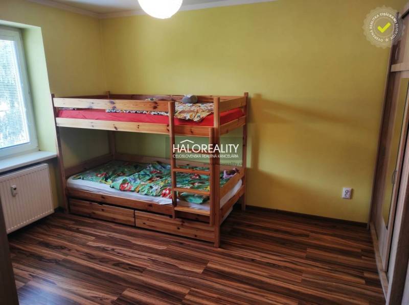 Gyerekszoba emeletes ággyal, sárga falakkal és fa dekorációjú padlóval egy háromszobás lakásban.