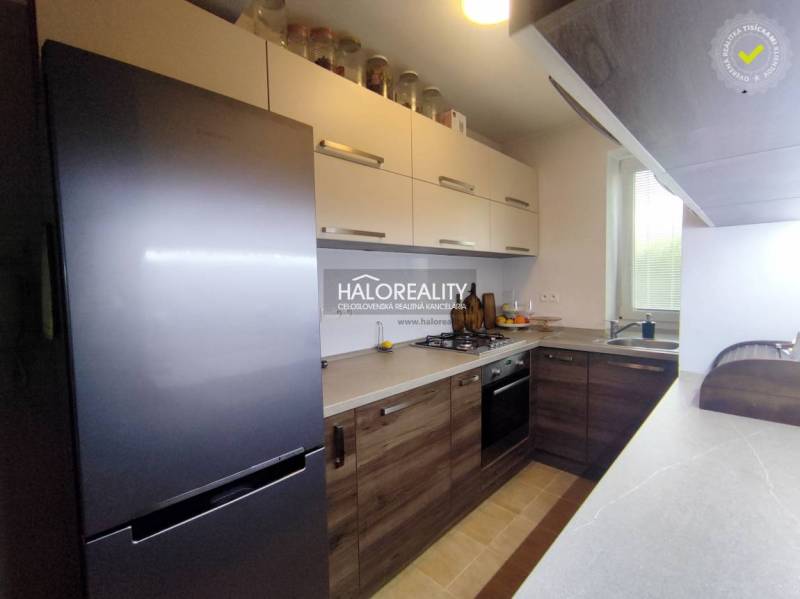 Konyha egy háromszobás lakásban, fa dekor padlóval és modern készülékekkel.