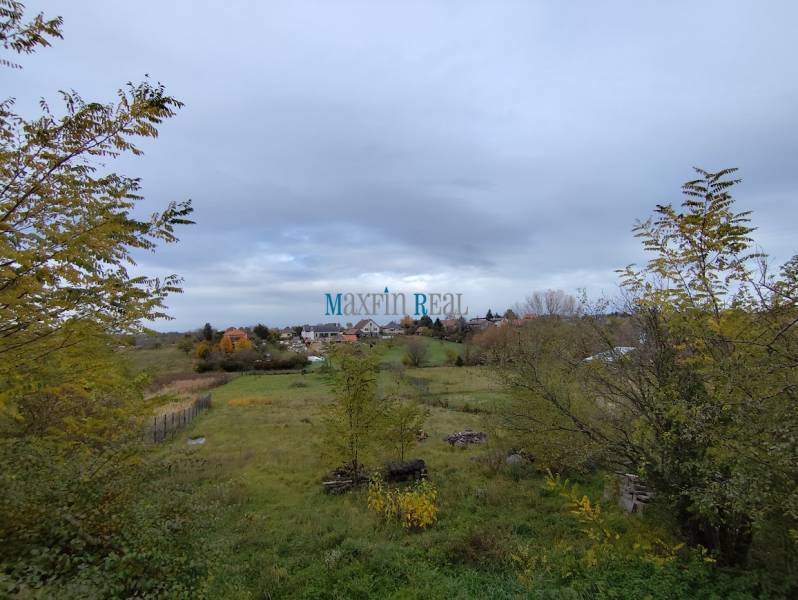 Nagy Bab városában található telek, amely lakhatásra van kijelölve, zöld növényzet és vidéki táj veszi körül.