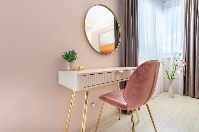 Családi ház belső tere fésülködőasztallal, tükörrel és dekoratív elemekkel.