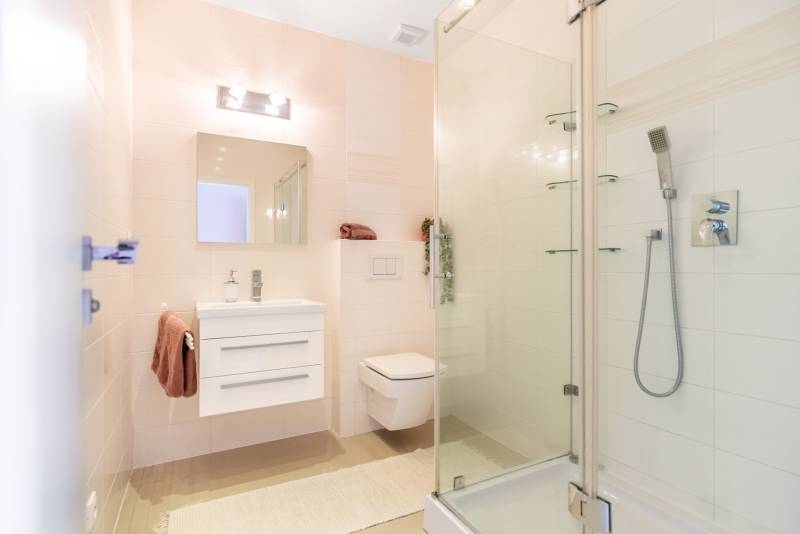 Fürdőszoba családi házban mosdóval, zuhanyzóval és WC-vel.