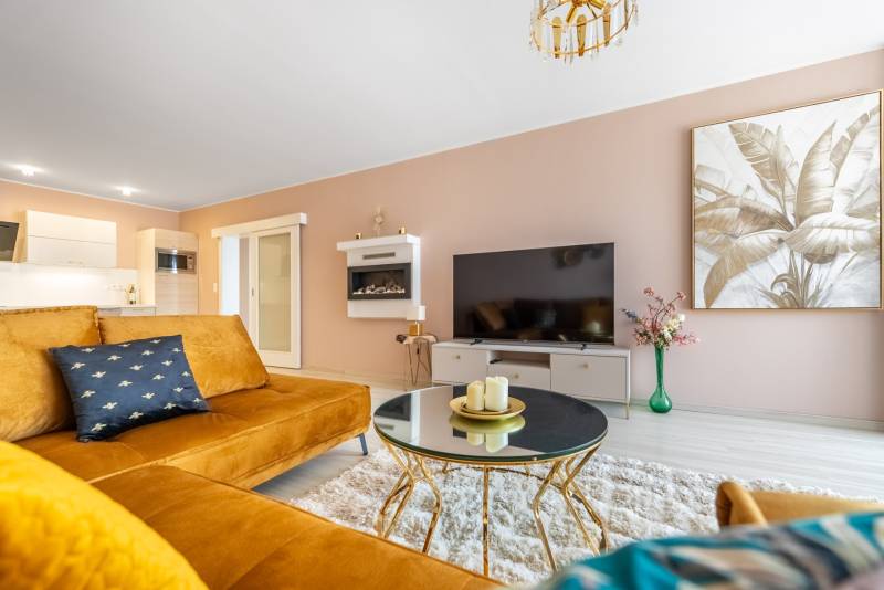 Nappali dekoratív festménnyel, kanapéval és asztallal egy családi házban.