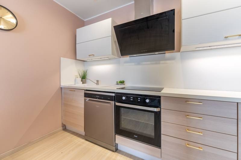 Konyha egy 4 szobás lakásban fa dekor padlóval és modern készülékekkel.