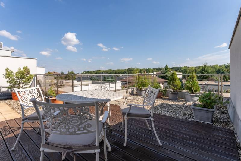 A Jazdecká utcai családi ház terasza Nagyszombatban virágtartókkal és ülőgarnitúrával.