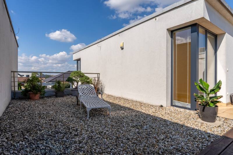 A Jazdecká utcai családi ház terasza Nagyszombatban zölddel és nyugággyal.