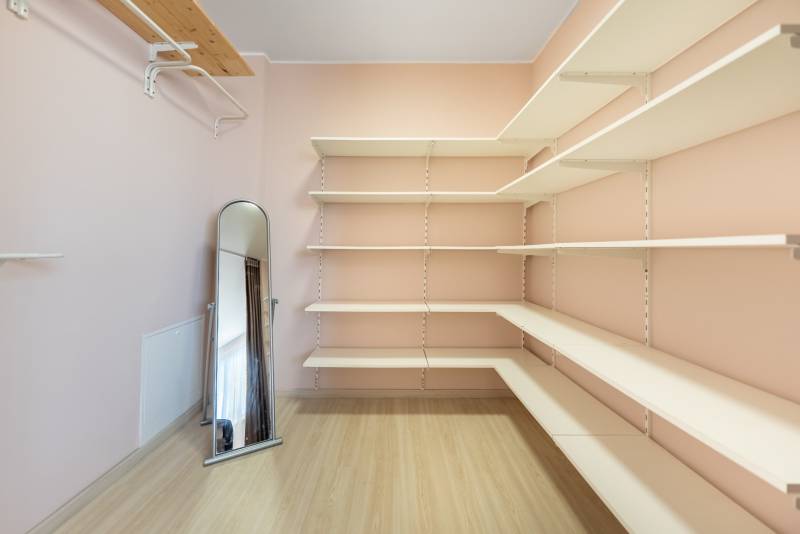 Gardrób családi házban polcokkal, álló tükörrel és fa dekoros padlóval.