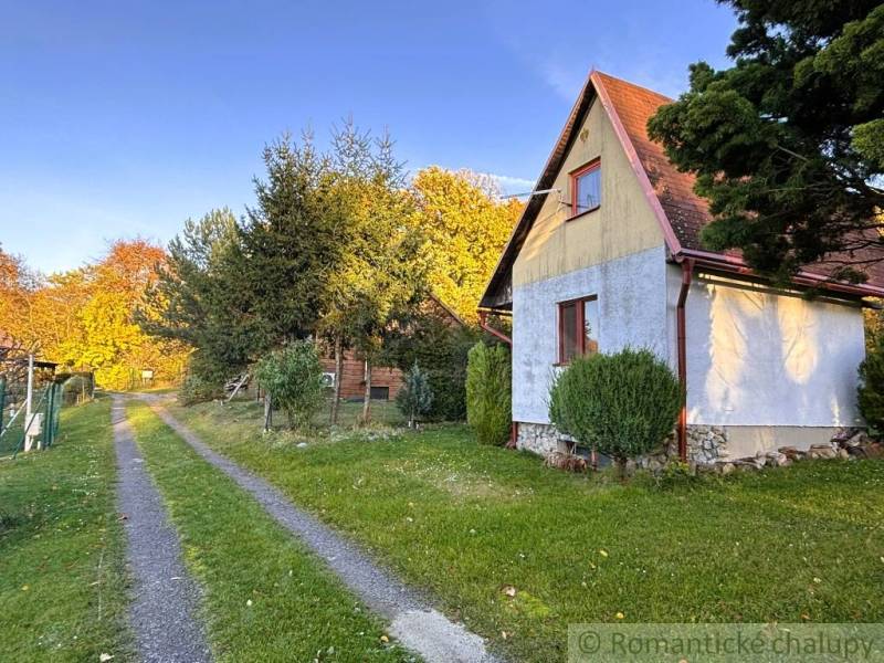 Kunyhó az útonál, Sološnicán, fákkal és gyepes területtel körülvéve ősszel.