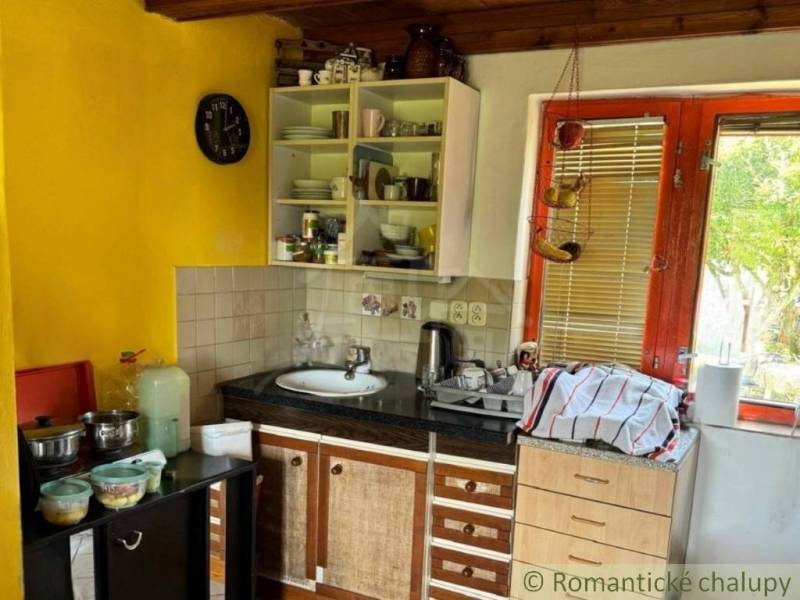 Konyha faházban fa mennyezettel és sárga fallal, alapvető edényekkel felszerelve.