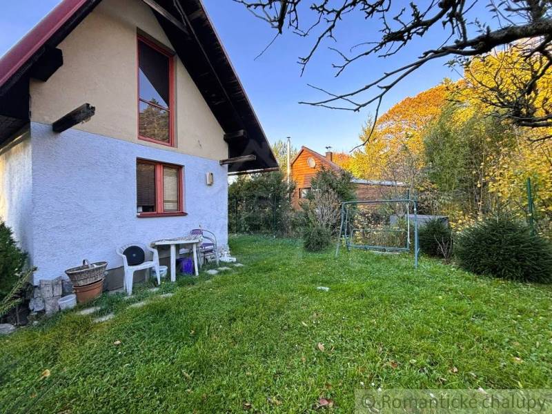 A szolosi ház külső része zöld gyep és fák által körülvéve.