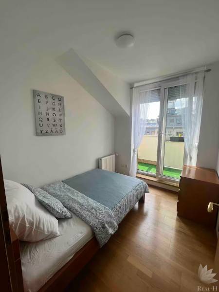 Világos szoba ággyal egy háromszobás lakásban, faldekoráció ábécével.