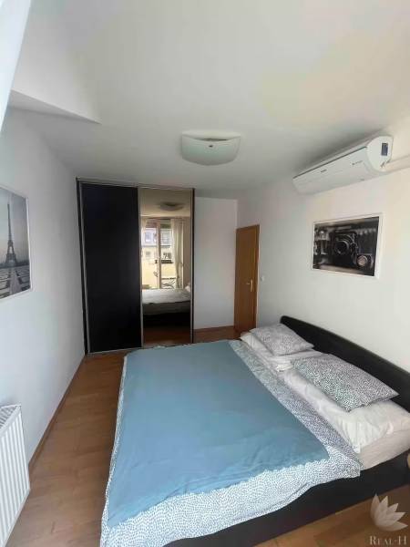 Hálószoba egy háromszobás lakásban ággyal, légkondicionálóval és beépített szekrénnyel.