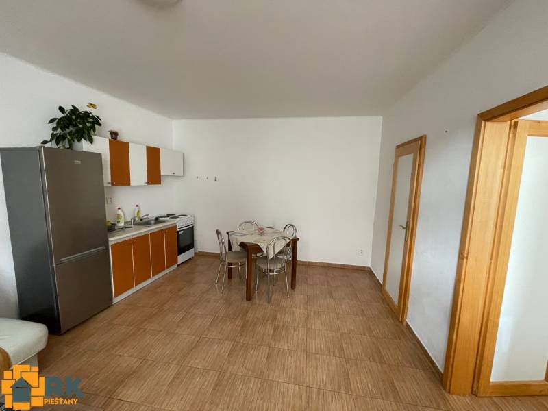 Családi ház konyhája csempével és étkezőasztallal.