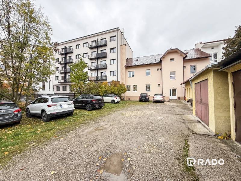 Parkoló és épületek a Zsolnai Pozsonyi utcában, irodák és lakóházak.