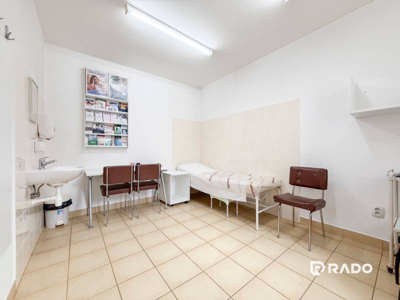 Szoba irodában csempével, mosdóval, székekkel és fekvőággyal.