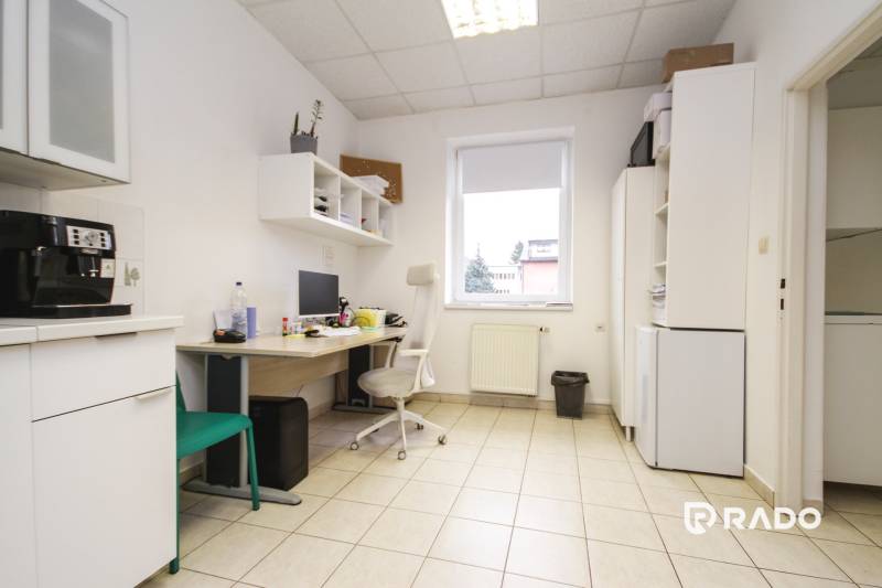 Iroda csempével, számítógéppel, bútorokkal és kávéfőzővel ellátott helyiség.