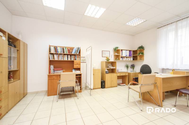 Irodák bútorokkal, székekkel és könyvespolcokkal, padló kerámia csempével.