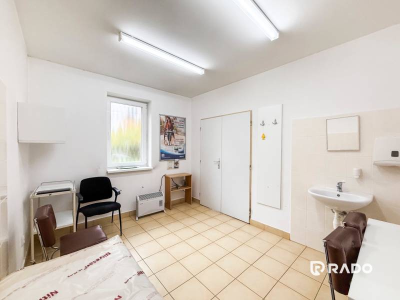 Rendelő mosdóval, székekkel és kilátással rendelkező ablakkal, világos dekorú padlóval.